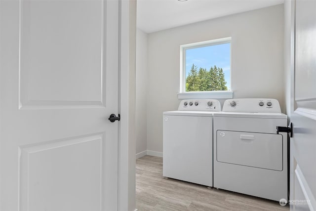 washroom featuring washer and clothes dryer and light hardwood / wood-style floors