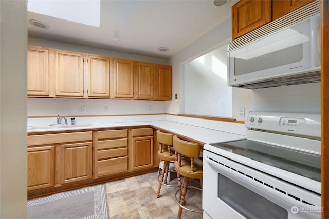 kitchen featuring backsplash, sink, and white appliances