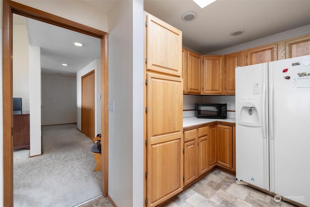 kitchen featuring white refrigerator with ice dispenser and light carpet