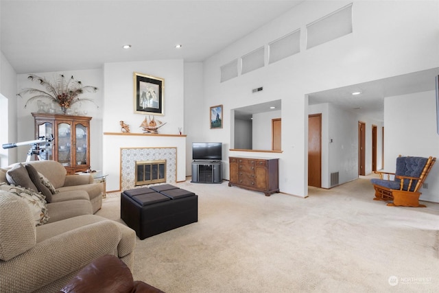 carpeted living room with a fireplace and high vaulted ceiling