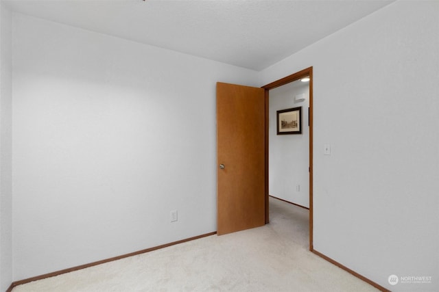 carpeted empty room with a textured ceiling