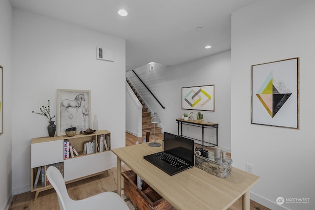 home office with light hardwood / wood-style floors