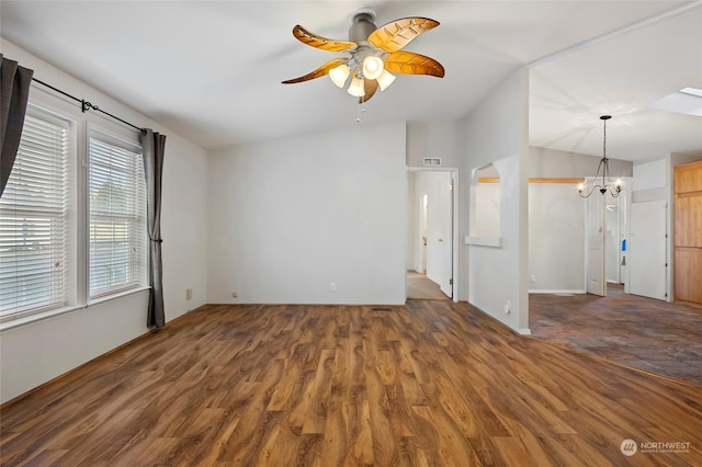 unfurnished living room with lofted ceiling, ceiling fan with notable chandelier, and dark hardwood / wood-style floors