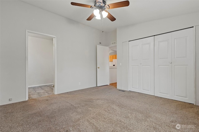 unfurnished bedroom featuring ceiling fan, a closet, and light carpet