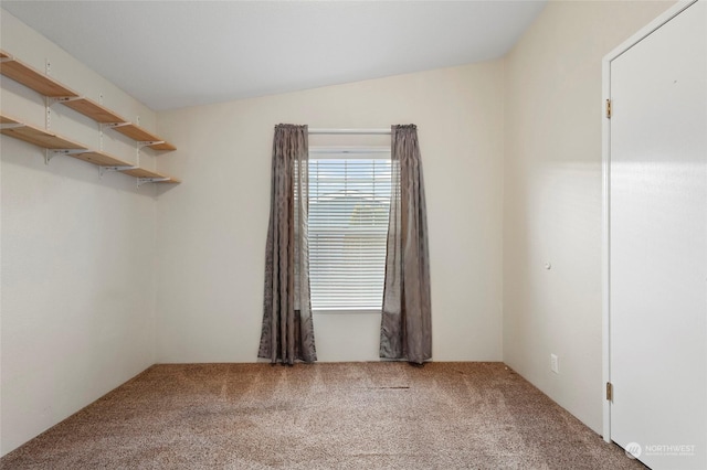 unfurnished room featuring carpet flooring and vaulted ceiling