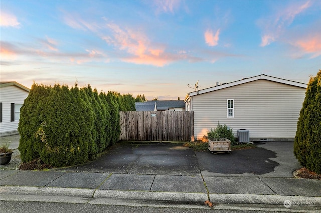 property exterior at dusk featuring central AC unit