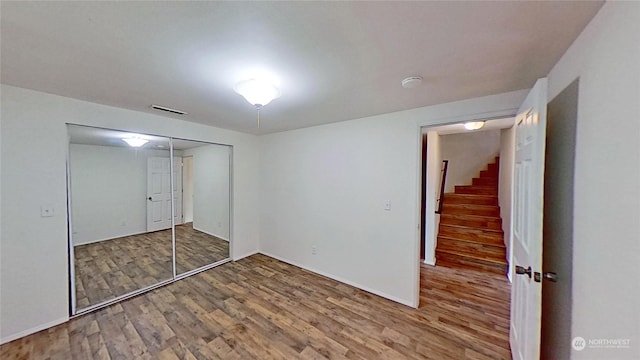 unfurnished bedroom featuring hardwood / wood-style flooring and a closet