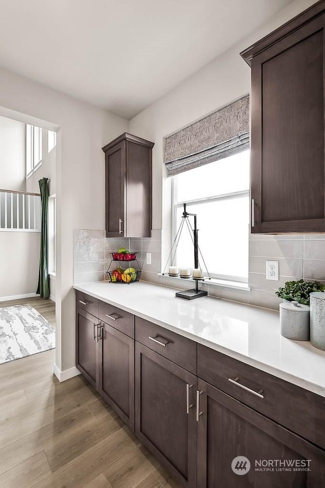 kitchen featuring decorative backsplash, hardwood / wood-style floors, and dark brown cabinets