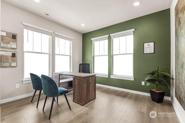 office with light hardwood / wood-style flooring and plenty of natural light