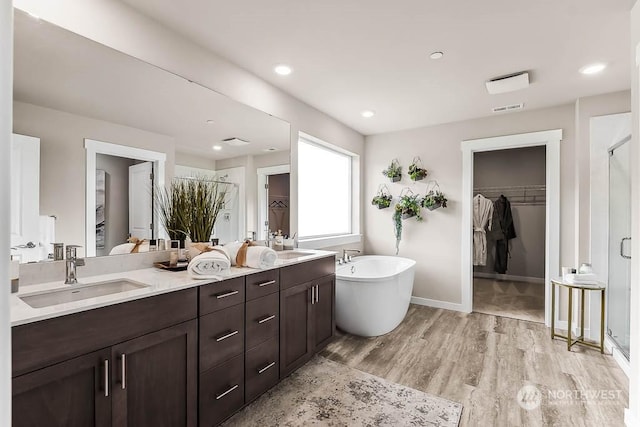 bathroom featuring hardwood / wood-style floors, vanity, and shower with separate bathtub