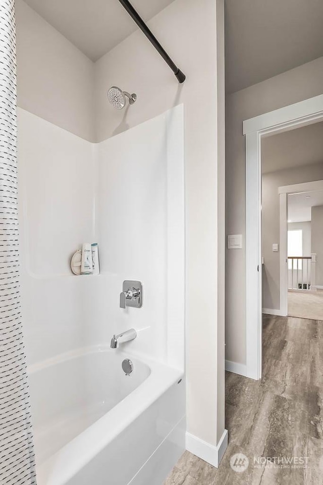 bathroom with wood-type flooring and tub / shower combination