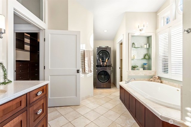 bathroom featuring vanity, lofted ceiling, tile patterned floors, stacked washer and dryer, and a washtub