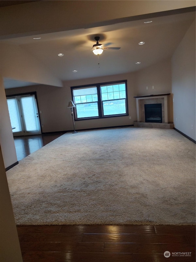 unfurnished living room with ceiling fan, a fireplace, and dark hardwood / wood-style floors