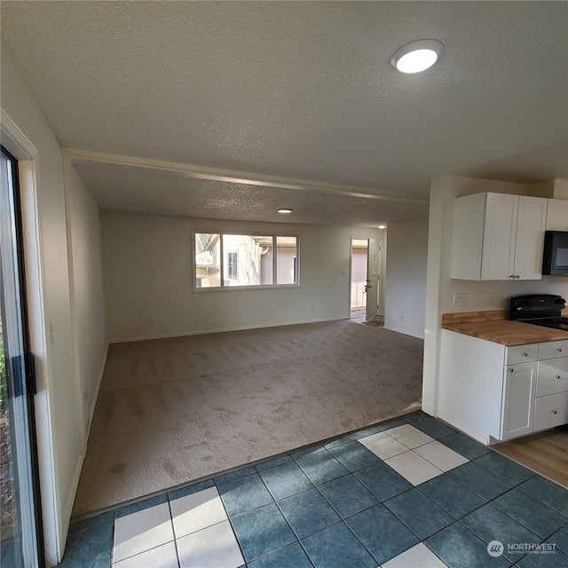 kitchen with wooden counters, light carpet, a textured ceiling, and white cabinets