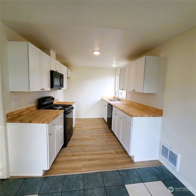 kitchen with black appliances, light wood-type flooring, and white cabinetry