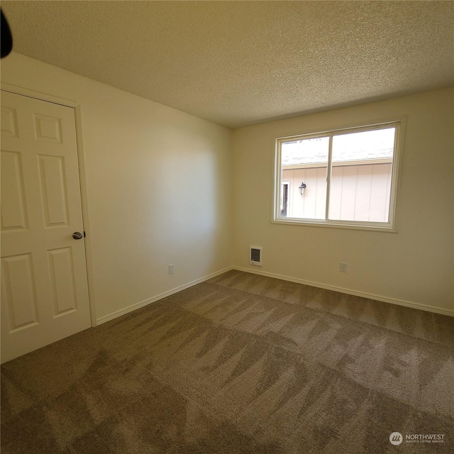 carpeted spare room featuring a textured ceiling