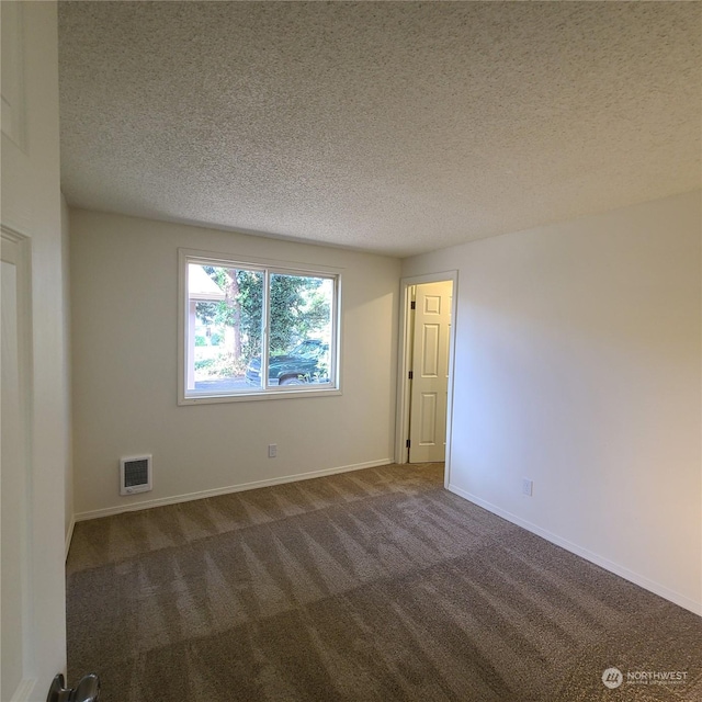 empty room featuring a textured ceiling and carpet floors