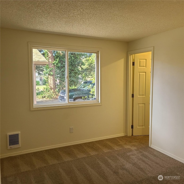 carpeted spare room with a textured ceiling