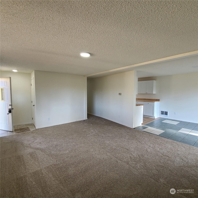 carpeted spare room featuring a textured ceiling