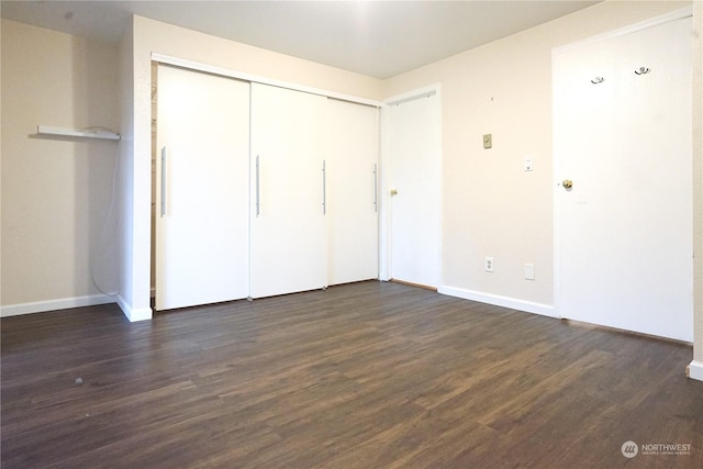 unfurnished bedroom with dark hardwood / wood-style flooring and a closet