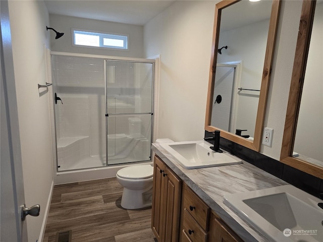 bathroom featuring toilet, hardwood / wood-style floors, vanity, and walk in shower