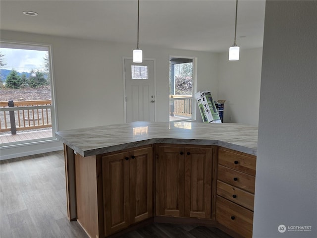 kitchen featuring decorative light fixtures, wood-type flooring, and kitchen peninsula