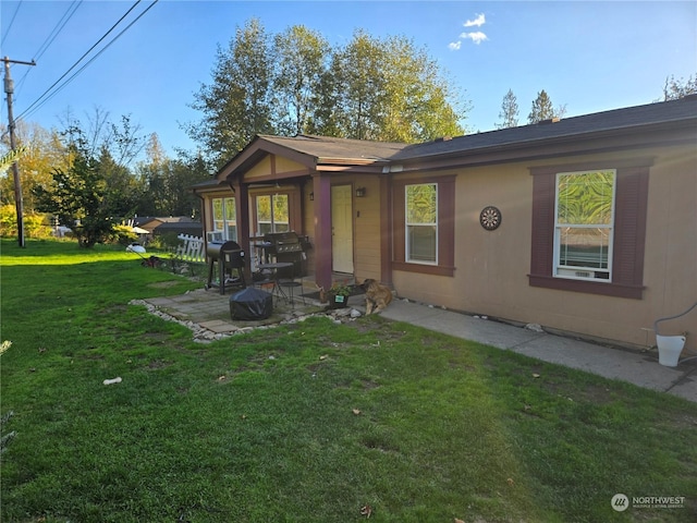 back of property featuring a patio area and a lawn