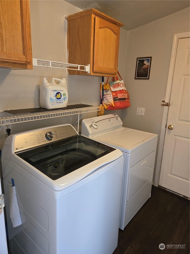 laundry room with cabinets, dark hardwood / wood-style floors, and washer and clothes dryer