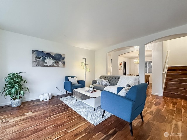 living room with dark wood-type flooring and a chandelier