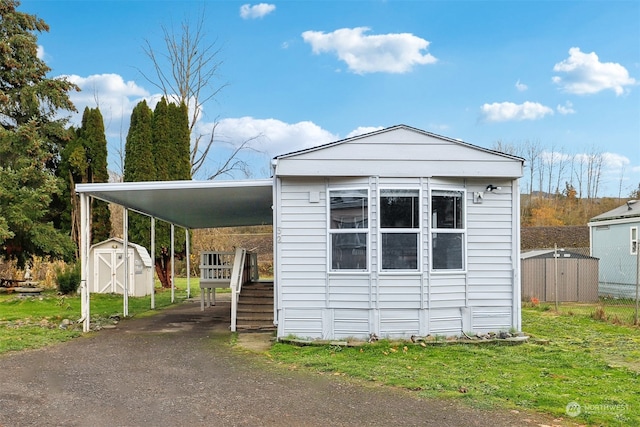 view of front facade featuring a carport and a storage unit