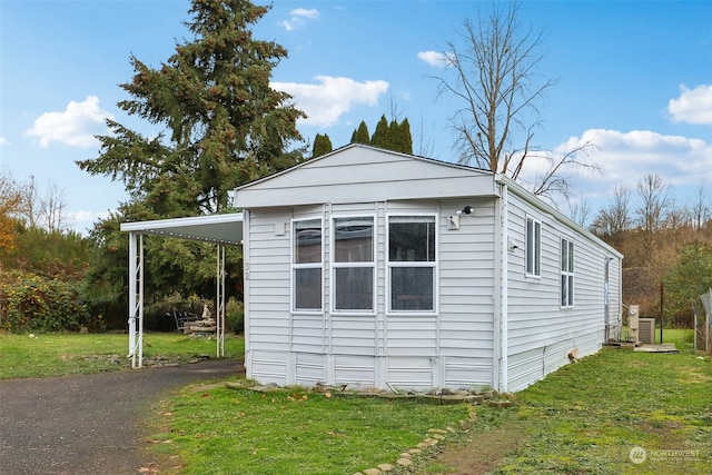 view of home's exterior with a carport and a yard