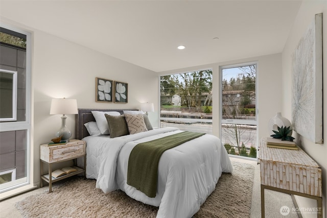 carpeted bedroom with multiple windows and recessed lighting