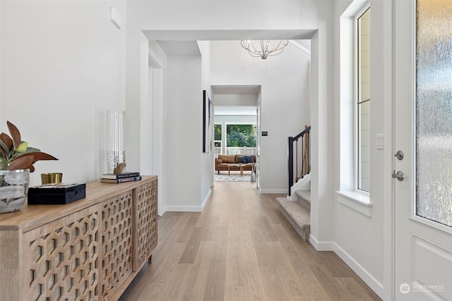 foyer entrance featuring light wood-type flooring and an inviting chandelier