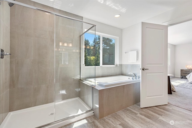 bathroom featuring hardwood / wood-style flooring and separate shower and tub