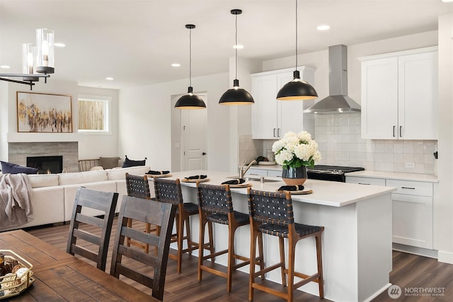 21416 116th Ave SE Unit 5, Kent, WA 98031 - kitchen with wall chimney range hood, dark wood finished floors, tasteful backsplash, a kitchen island with sink, and recessed lighting
