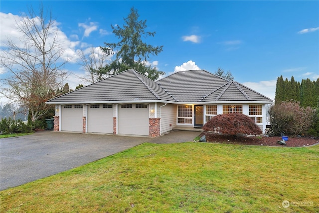 ranch-style house featuring a front yard and a garage