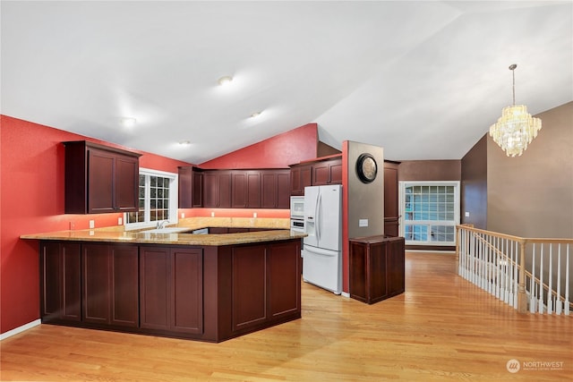 kitchen featuring lofted ceiling, hanging light fixtures, light hardwood / wood-style flooring, kitchen peninsula, and white appliances