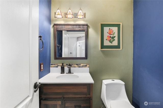 bathroom featuring vanity, toilet, and decorative backsplash