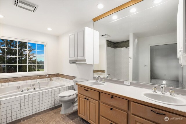 bathroom with vanity, toilet, tile patterned flooring, and tiled bath