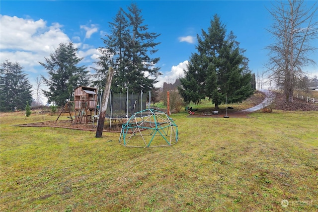 view of yard featuring a trampoline and a playground