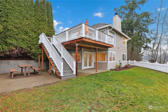 rear view of house with a patio, a yard, and a deck