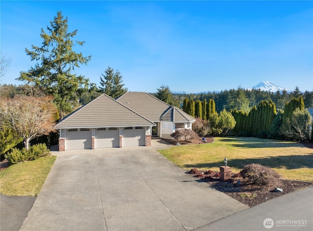 single story home featuring a garage, a mountain view, and a front lawn