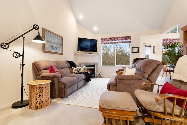 carpeted living room featuring a fireplace and high vaulted ceiling