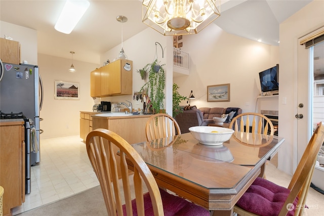 dining space featuring high vaulted ceiling and an inviting chandelier