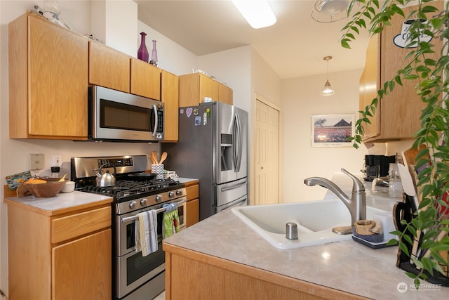 kitchen featuring pendant lighting, sink, and appliances with stainless steel finishes