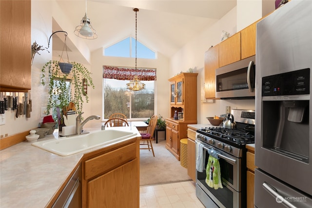 kitchen featuring pendant lighting, high vaulted ceiling, sink, appliances with stainless steel finishes, and a chandelier