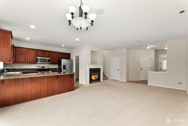 kitchen featuring kitchen peninsula, light carpet, sink, and appliances with stainless steel finishes