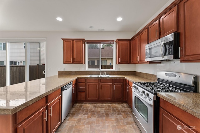 kitchen with kitchen peninsula, a wealth of natural light, sink, and appliances with stainless steel finishes