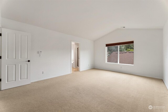 unfurnished room with carpet floors and vaulted ceiling