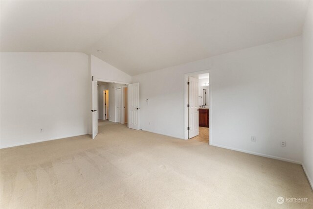 unfurnished room with light carpet and lofted ceiling